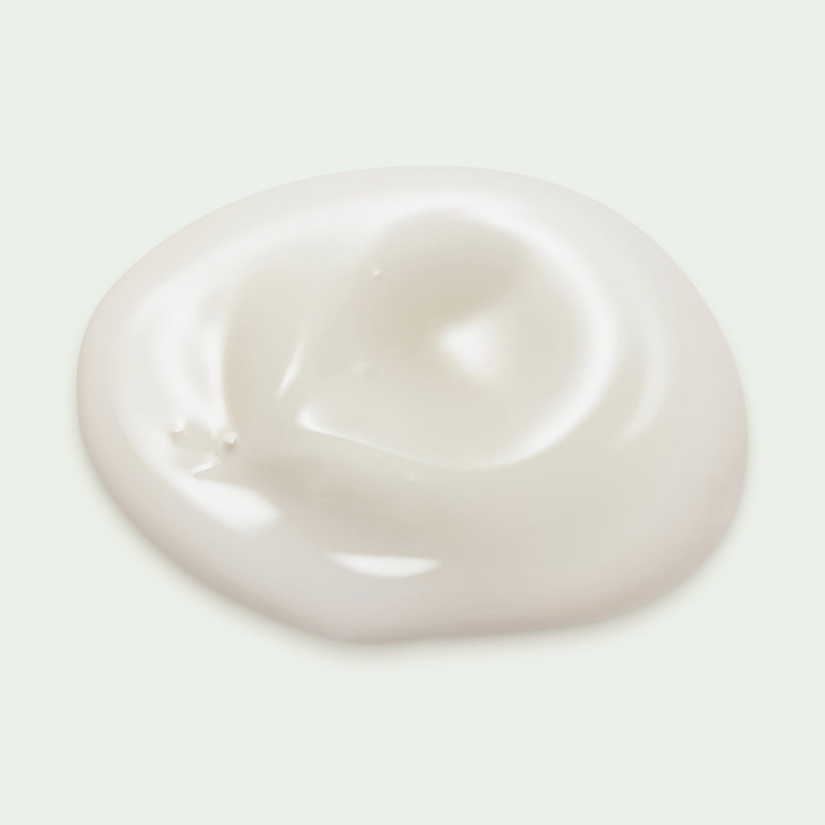 Ein cremeweißer Klecks maria nila Coils & Curls Weightless Curl Definer auf einem schlichten, hellen Hintergrund.