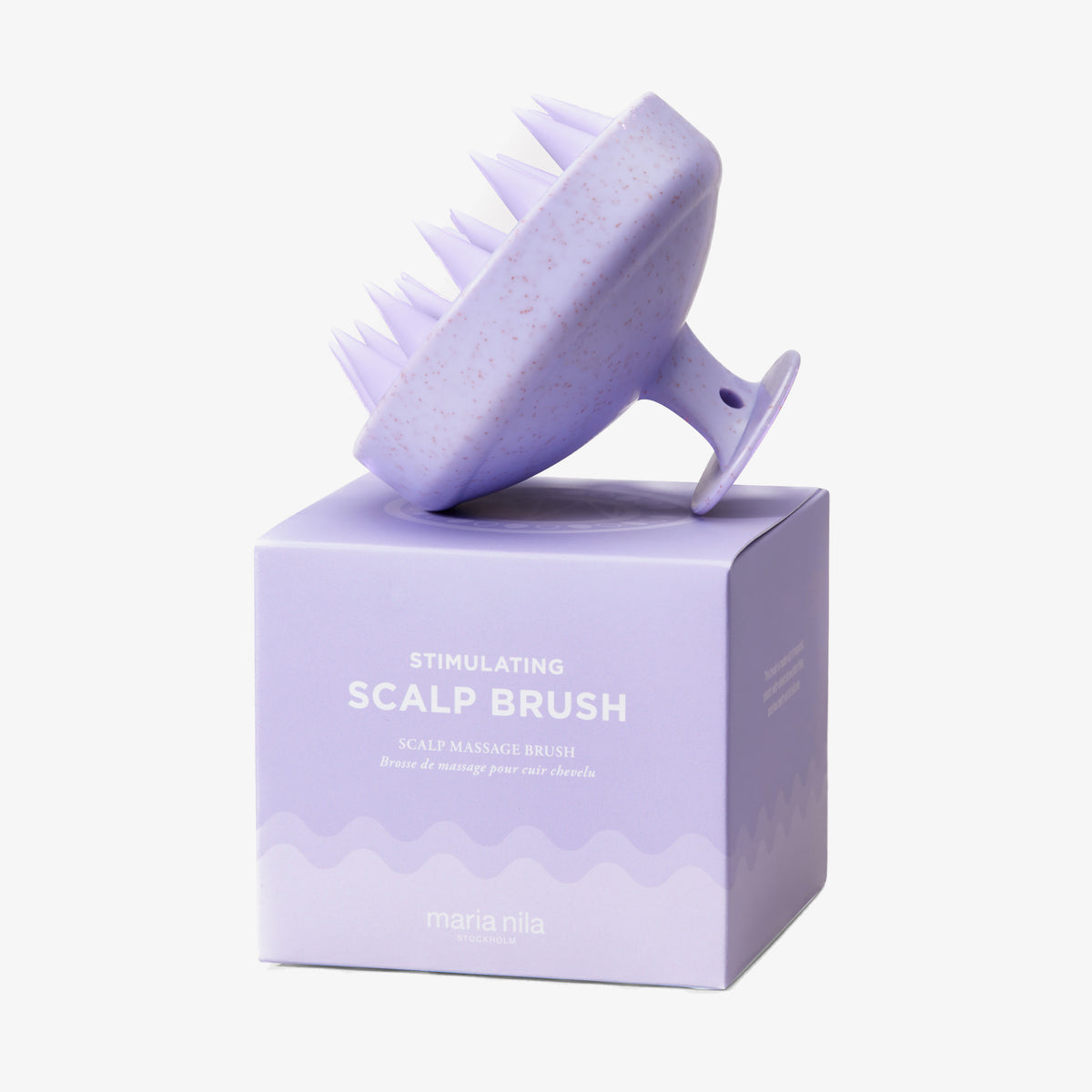 Eine lavendelfarbene Stimulating Scalp Brush von maria nila ruht auf der dazugehörigen Schachtel.