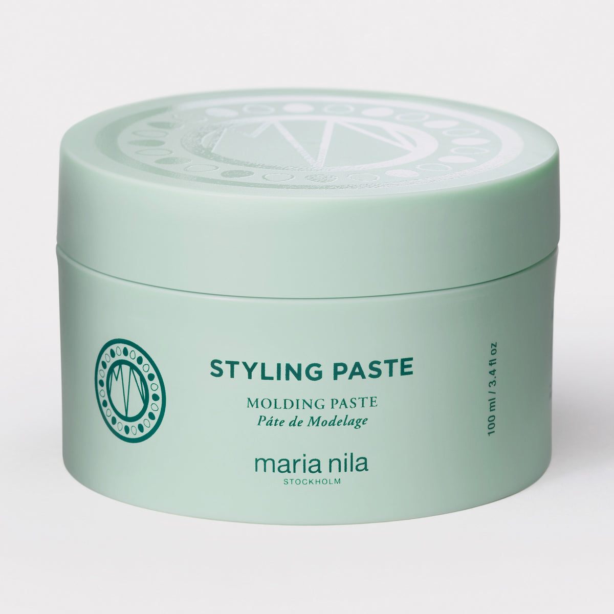 Ein hellgrüner Behälter der maria nila Styling Paste vor weißem Hintergrund.