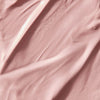 Zart strukturierte, rosafarbene Creme- oder Lotiontextur mit sanften Wellen.