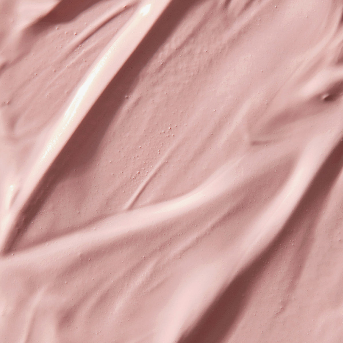 Zart strukturierte, rosafarbene Creme- oder Lotiontextur mit sanften Wellen.