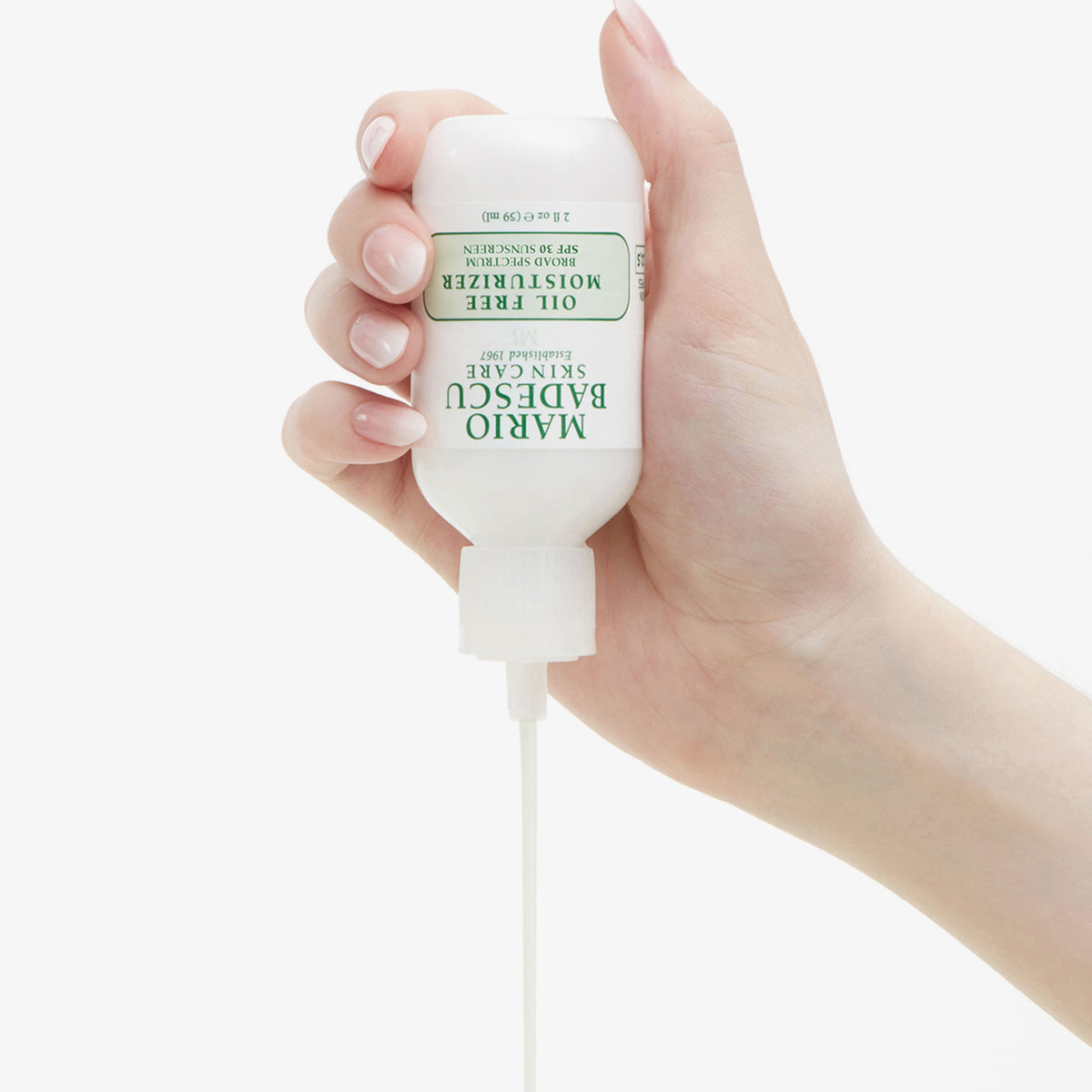 Eine Hand spendet einen Strahl von Mario Badescu Oil Free Moisturizer SPF 30 aus der Flasche.