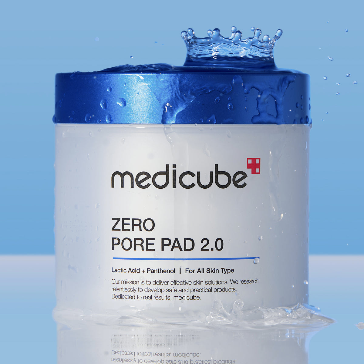 Ein Zero Pore Pad 2.0-Behälter mit Wasserspritzern auf dem blauen Deckel vor einem blauen Hintergrund.