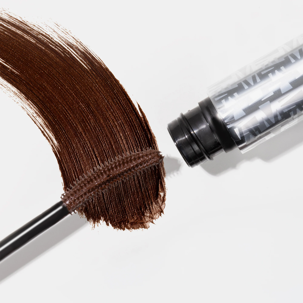 Mesauda Beauty Femuline™ Brownie Mascara-Tube geöffnet, Bürste und Streichen der braunen Wimperntusche auf weißem Hintergrund dargestellt.