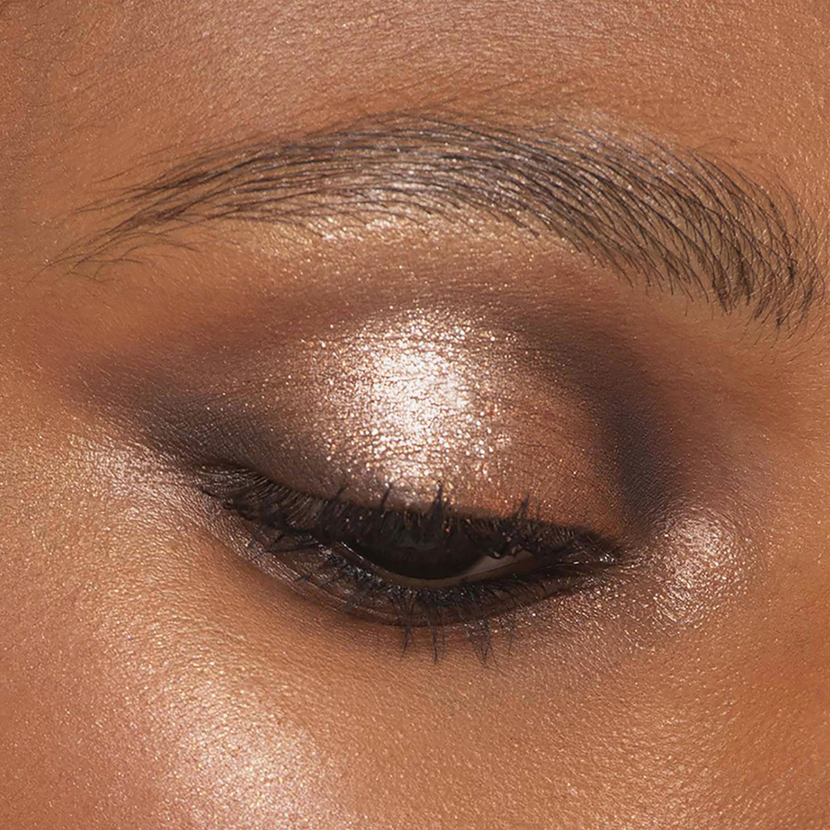 Ein mit der Bare Harmony 2.0 Palette von Mesauda Beauty geschminktes Auge, mit schimmernden goldenen und braunen Lidschatten.