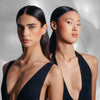Zwei dunkelhaarige Models mit dem „Flush of Blush“ auf den Wangen, posieren mit vor einem hellen Hintergrund.