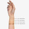 Eine Hand zeigt auf dem inneren Unterarm vier Lust For Shine Highlighter-Swatches (Farbtöne 101-104) von Mesauda Beauty.