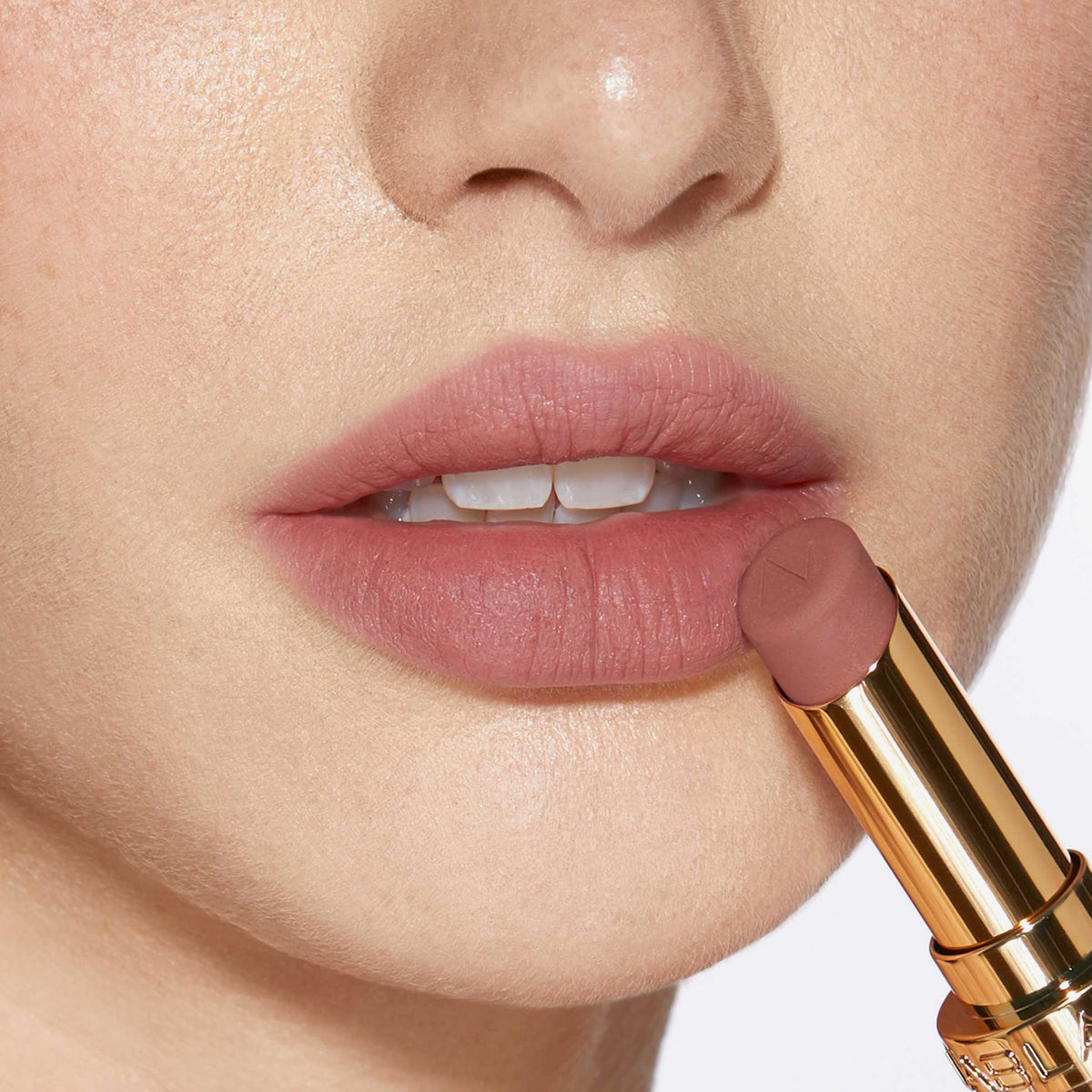 Nahaufnahme einer Person mit einem helleren Hautton, die sich den Beyond Blurry Lipstick, in der Farbe celeste, auf die Lippen aufträgt.