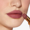 Nahaufnahme einer Person mit einem helleren Hautton, die sich den Beyond Blurry Lipstick, in der Farbe dea, auf die Lippen aufträgt.