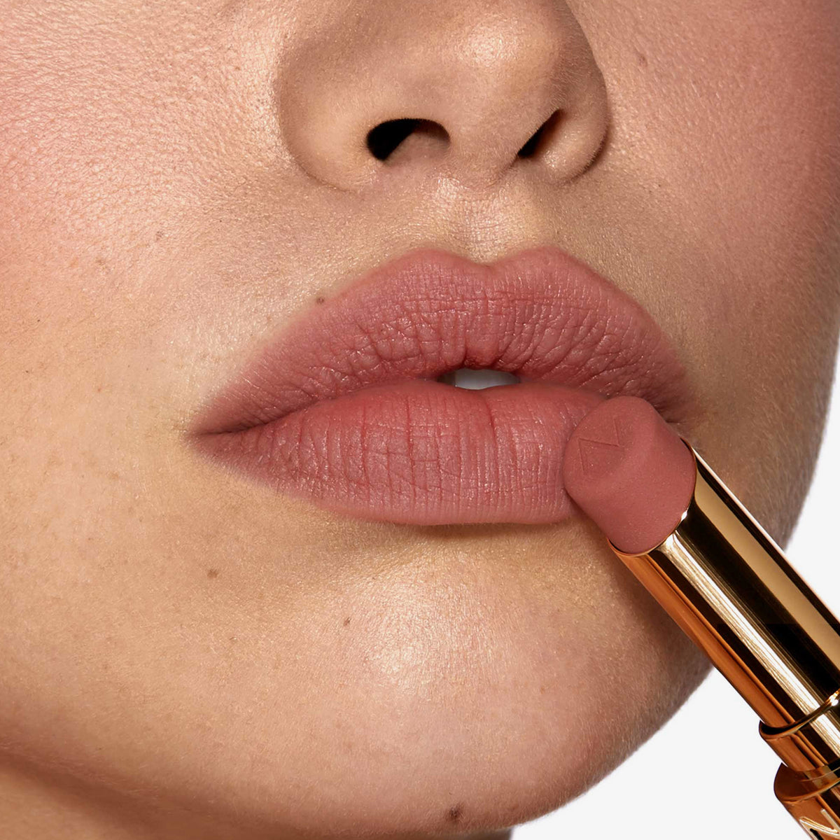 Nahaufnahme einer Person, die sich den Beyond Blurry Lipstick, in der Farbe divinze, auf die Lippen aufträgt.