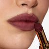 Nahaufnahme einer Person, die sich den Beyond Blurry Lipstick, in der Farbe nocturna, auf die Lippen aufträgt.
