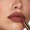 Nahaufnahme einer Person mit einem helleren Hautton, die sich den Beyond Blurry Lipstick, in der Farbe saint, auf die Lippen aufträgt.