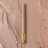 NABLA Cupid’s Arrow Longwear Stylo Arrow Shine in der Nuance Mirror auf schimmernder, strukturierter Oberfläche in warmen Rosé-Gold-Tönen.