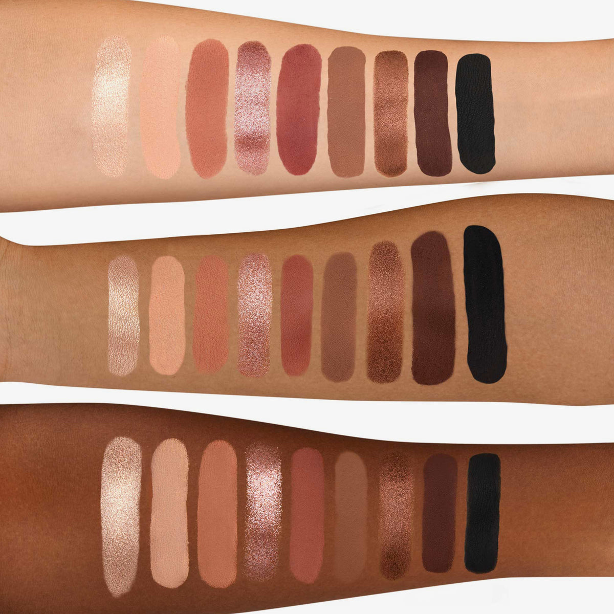Drei Arme mit unterschiedlichen Hauttönen zeigen Swatches der Side By Side Nude Palette Baby, die Nude-Lidschatten von leicht schimmernden bis zu dunklen, matten Tönen umfasst.