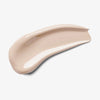 Ein glatter Fleck Skin Realist Tinted Balm in der Farbe 05 Fair auf weißem Hintergrund.