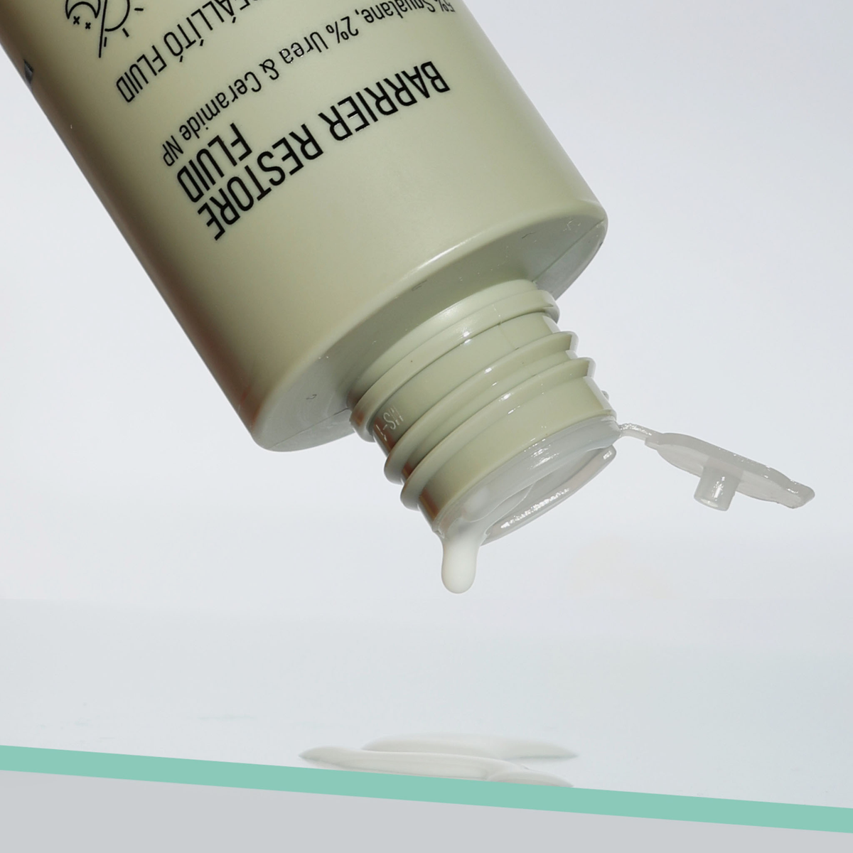 Eine offene Flasche NERDS. Barrier Restore Fluid mit etwas Flüssigkeit, die auf eine ebene Fläche tropft.