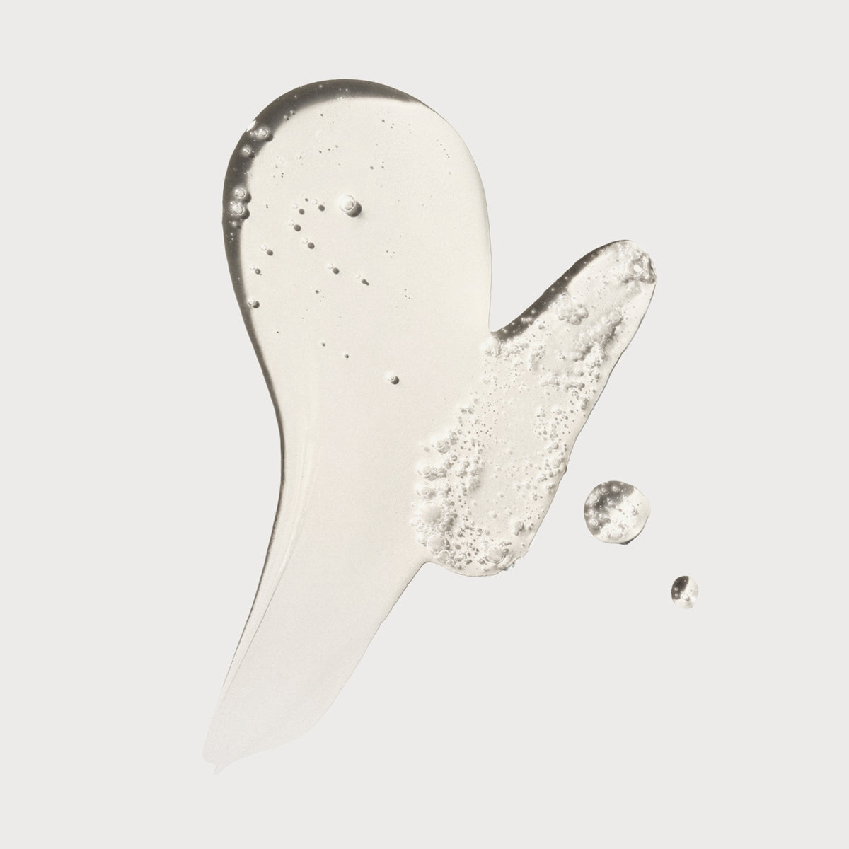 Klarer Klecks des N°9 Bond Protector Nourishing Hair Serum auf weißem Hintergrund.