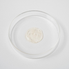 Eine durchsichtige Petrischale enthält in der Mitte eine kleine Menge des durchsichtigen, sprudelnden Bio-Pilixin® Shampoo+Women von Scandinavian Biolabs auf weißem Hintergrund.