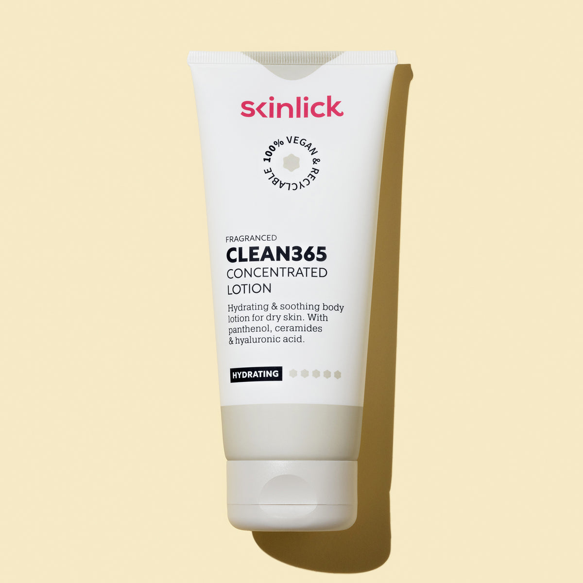 Eine weiße Tube Clean365 Concentrated Lotion liegt auf einem gelben Hintergrund und wirft einen Schatten.