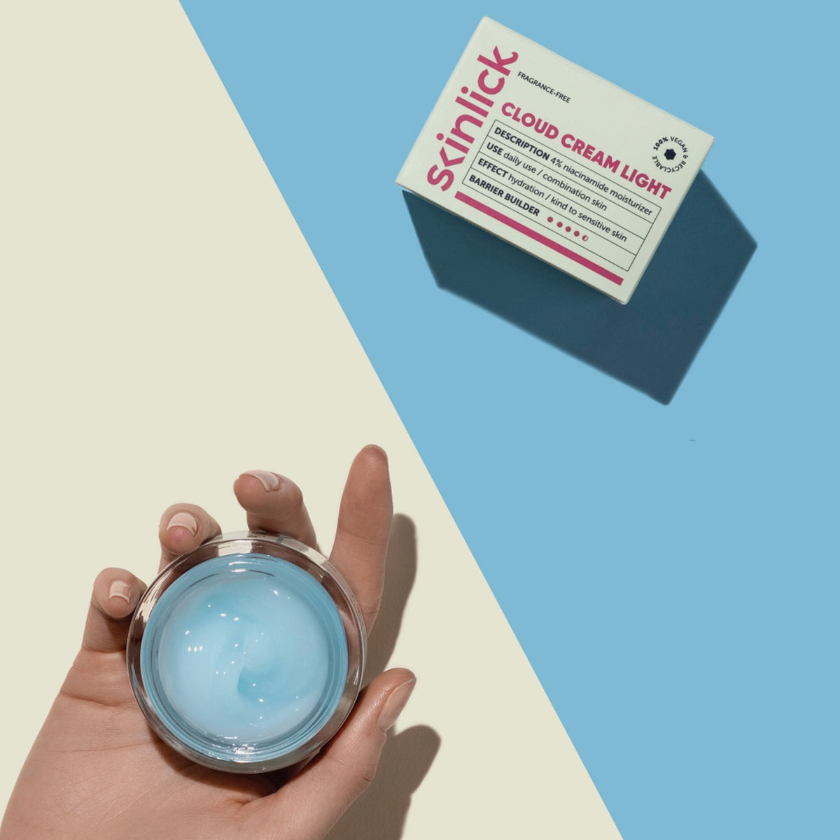 Eine Hand hält einen Tiegel Cloud Cream Light; die Schachtel liegt daneben auf einem geteilten blau-cremefarbenen Hintergrund.