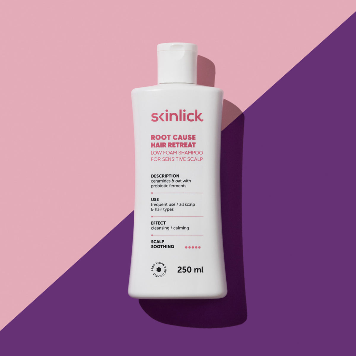 Weiße Flasche Root Cause Hair Retreat Shampoo auf rosa Hintergrund mit einem violetten diagonalen Streifen, der einen Schatten wirft.