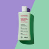 Eine Flasche Root Cause Sebum Balance Shampoo auf einem gespaltenen pastellgrünen und violetten Hintergrund mit einem dramatischen Schatten.
