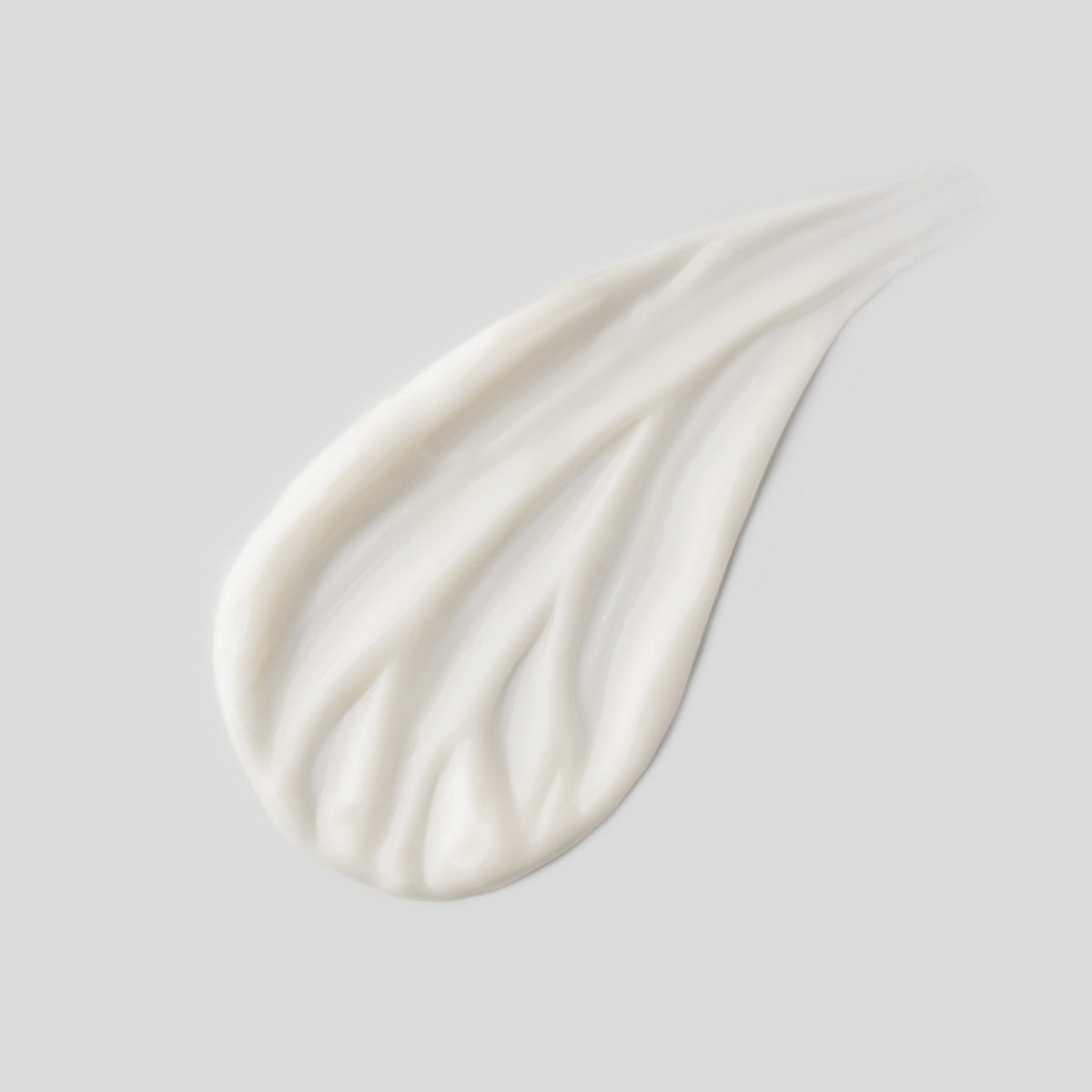 Nahaufnahme der weißen Creme auf einem grauen Hintergrund.