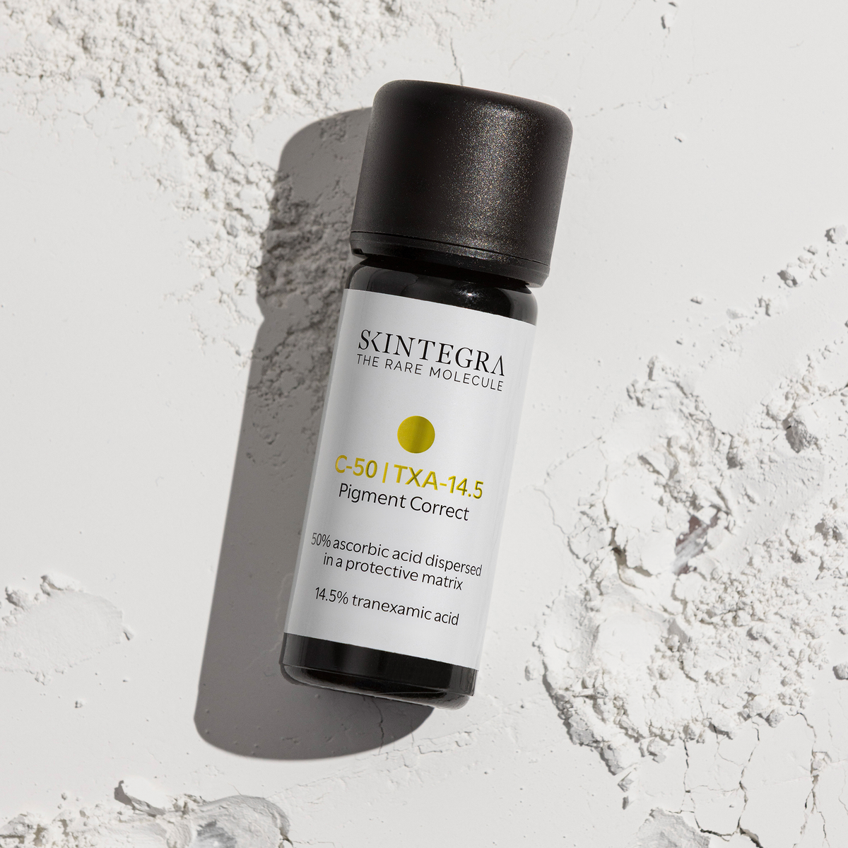 Eine Flasche Skintegra C-50 I TXA-14.5 Pigment Correct Serum steht auf einer weißen, strukturierten Oberfläche.