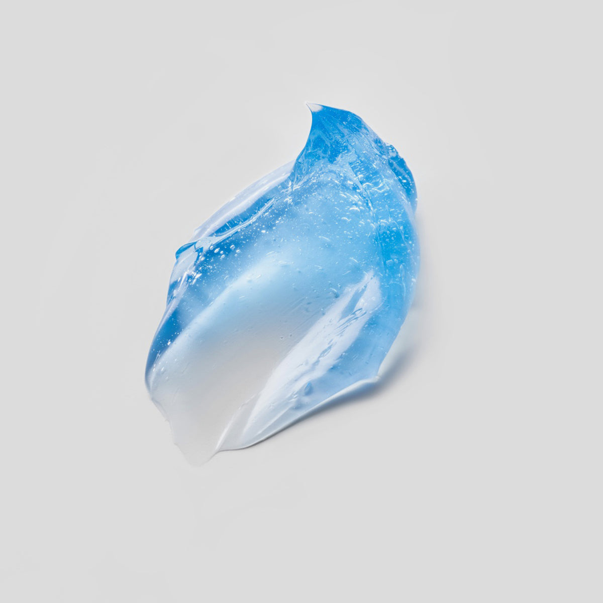 Ein gewirbelter Tupfer aus durchscheinendem blauem Hyperdew-Gel auf hellgrauem Hintergrund.