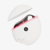 STYLPRO Gua Sha in Weiß mit silberner Massagefläche und leuchtendem pinkem LED-Licht, der mit Deckel dargestellt ist.