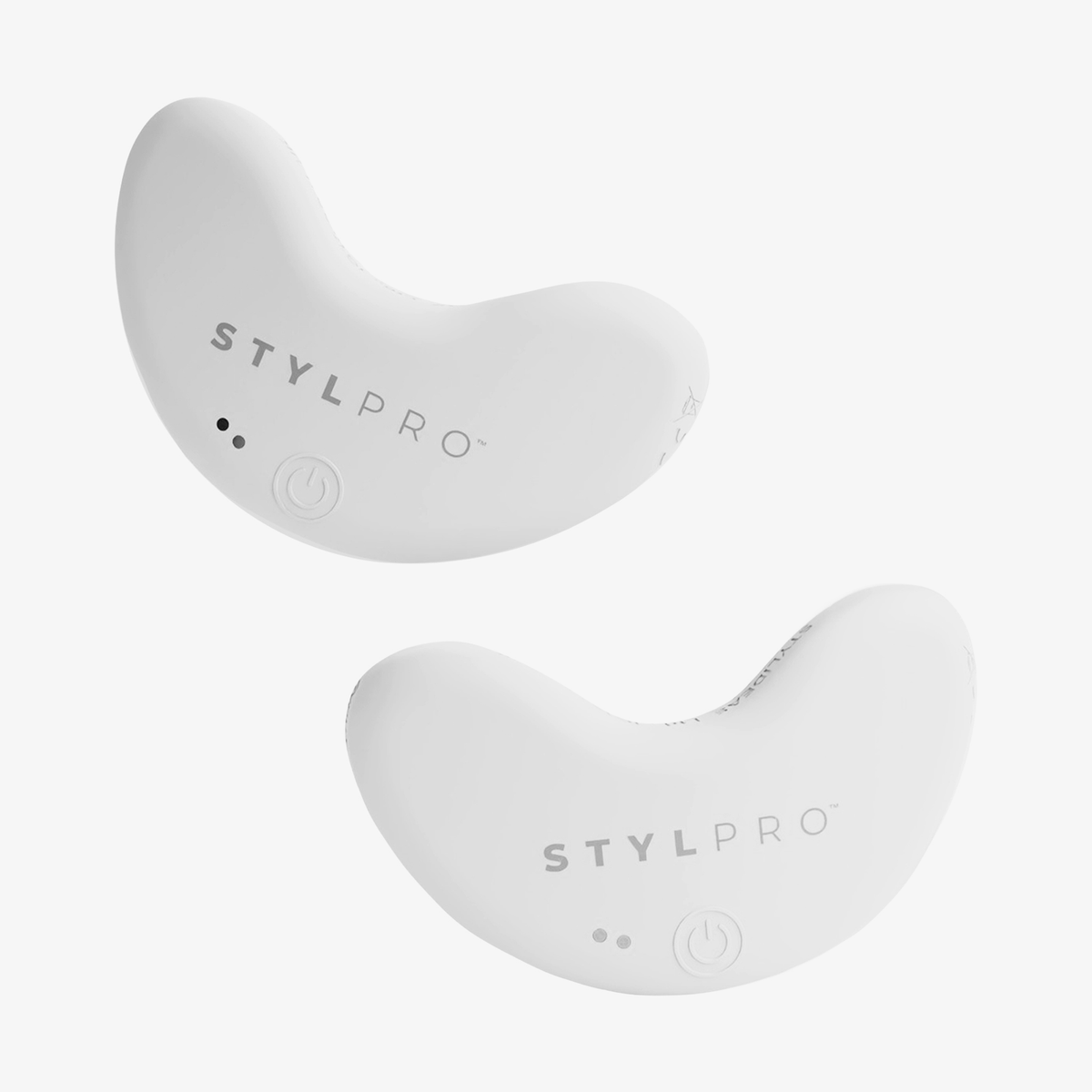 Zwei weiße, halbmondförmige STYLPRO LED Patch Duo-Geräte mit Tasten und Kontrollleuchten, nebeneinander auf weißem Hintergrund.