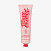 Rosa Tube des „Cherry Blush Rapid Warming Balm“ von The Fox Tan mit roten Schriftzügen und Kirschgrafik – hergestellt in Australien.