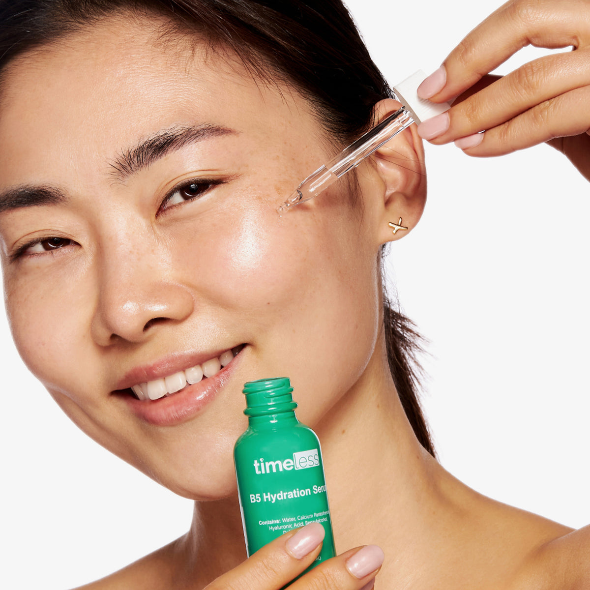 Eine Person trägt mit einer Pipette das Vitamin B5-Serum auf ihr Gesicht auf.