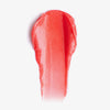 Ein Klecks Sheen Screen Hydrating Lip Balm SPF50 mit seinem leuchtend roten Farbton glänzt auf einem weißen Hintergrund.