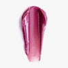 Ein Muster des Sheen Screen Hydrating Lip Balm SPF50 in glänzendem Pink, verschmiert auf weißem Hintergrund.