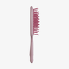 Eine UNbrush Detangling Hair Brush in Rosa mit gebogenen, unförmigen Borsten ist auf einem weißen Hintergrund abgebildet.
