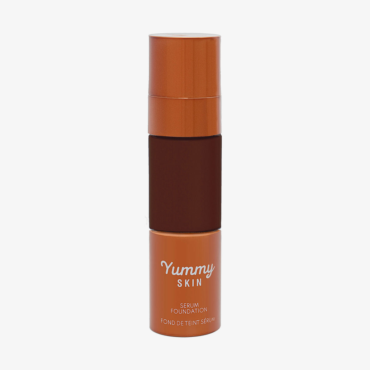 Eine halbtransparente und bronzene Flasche Yummy Skin Serum Foundation 25W mit tiefbraunem Inhalt.