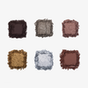 Sechs aufgebrochene Lidschatten-Farbtöne aus der NABLA „Cutie Palette Platinum“ in matten und schimmernden Braun-, Silber- und Goldnuancen auf weißem Hintergrund.