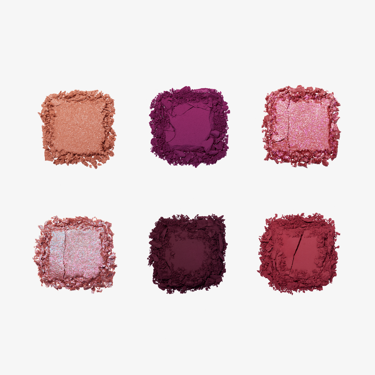 Sechs zerbröselte Lidschatten in Rosa-, Pink- und Beerentönen aus der NABLA Cutie Palette „Wild Berry“ auf weißem Hintergrund.