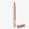 Ein roségoldener Kajalstift mit der Aufschrift „NABLA Cupid’s Arrow Longwear Stylo Arrow Shine“, dessen Kappe abgenommen und daneben platziert wurde.