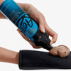 Hand trägt braunen Aero One Hour Express Self Tanning Foam aus blau-schwarzer Flasche auf einen schwarzen Applikatorhandschuh