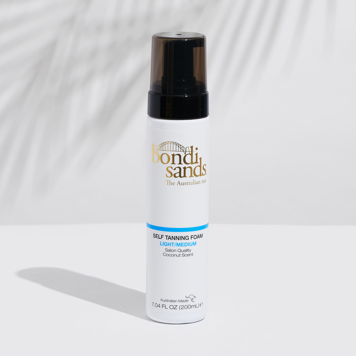 Weiße Flasche Bondi Sands Self Tanning Foam auf einer weißen Oberfläche mit Schatten im Hintergrund
