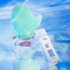 Ein mintgrüner Bräunungshandschuh und eine Flasche Technocolor 1 Hour Express Self Tanning Foam Sapphire auf einem wasserblauen Hintergrund.