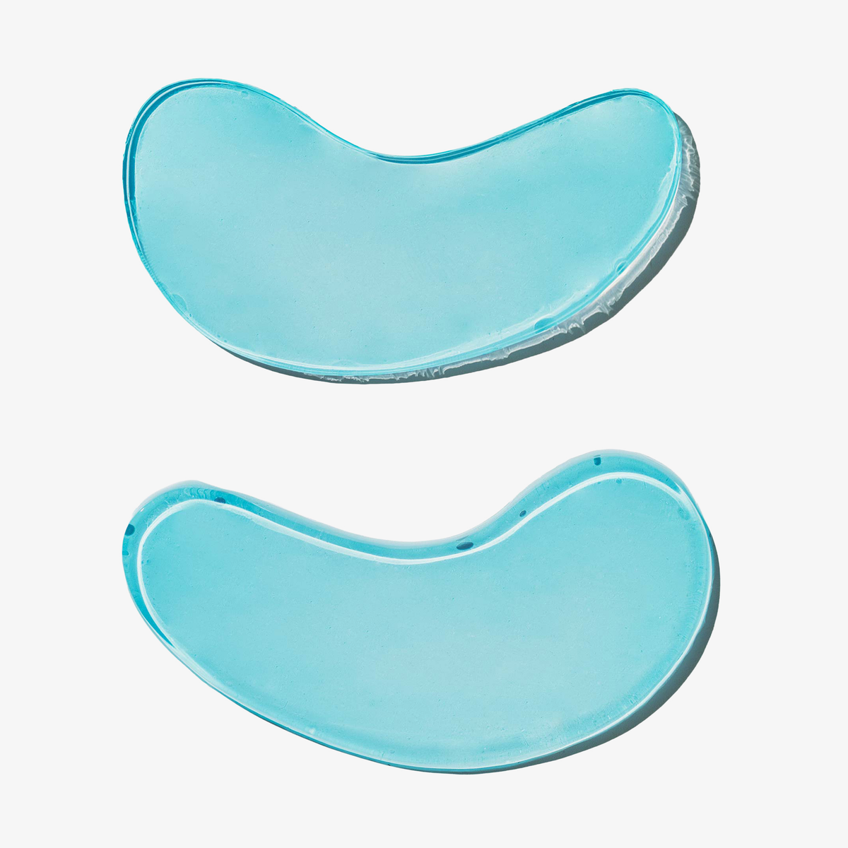 Zwei durchscheinende, hellblaue, halbmondförmige Hydrate + De-Puff Eye Patches von breakout+aid.