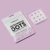 Eine Packung Breakout+Aid Microneedle Dots gegen Pigmentflecken und eine durchsichtige Schale mit neun runden Pflastern.