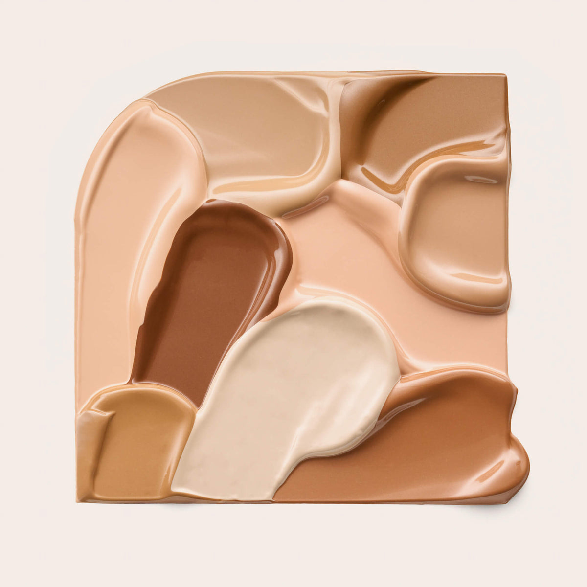 Mehrere ineinander fließende Swatches des Soft Glam Filter Fluid in Braun-, Beige- und Cremetönen auf cremefarbenem Hintergrund.