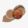 Runde geöffnete bronzefarbene Dose des Yummy Skin Blurring Balm Powder vor einem Farbstreifen der Shade 5.5.