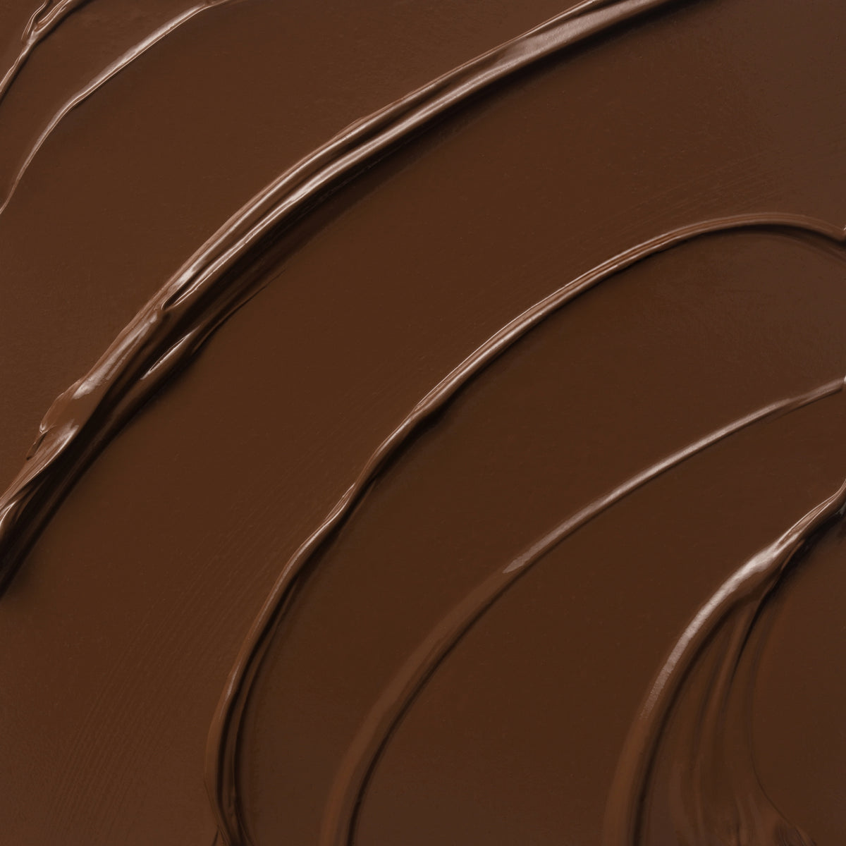 Nahaufnahme der cremigen Textur des Yummy Skin Lift & Flex Concealer 16 in dunklem Schokobraun.