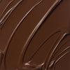 Nahaufnahme der cremigen Textur des Yummy Skin Lift & Flex Concealer 18 in Schokobraun.