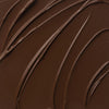Nahaufnahme der cremigen Textur des Yummy Skin Lift & Flex Concealer 20 in tiefem Schokobraun.